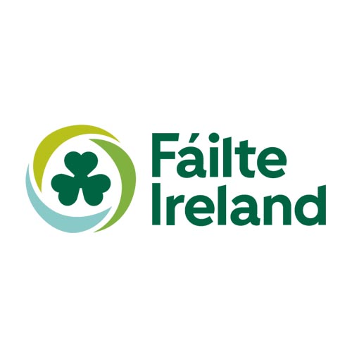 Fáilte Ireland Logo – A green and blue circular emblem with a shamrock in the center, accompanied by the text "Fáilte Ireland," representing Ireland’s National Tourism Development Authority.